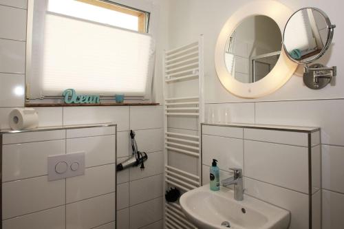 奥斯特巴德·哥伦F-1093 Villa Elise Ferienwohnung Nr 01的白色的浴室设有水槽和镜子