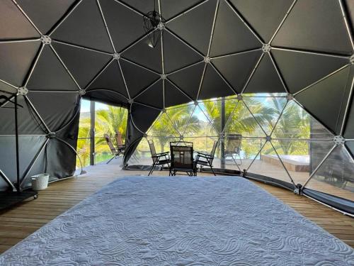 瓜塔佩Glamping Montecarlo Domo Geodesico y Sauna Finlandés Guatapé的一个带桌椅的大型帐篷