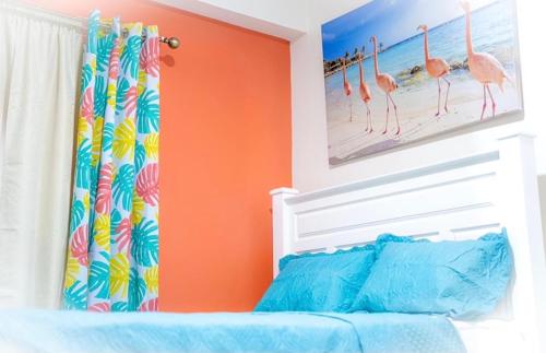 金斯敦Royal Bliss Apartment Suites的一间卧室设有橙色的墙壁和一张带婴儿床的床