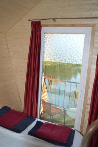 珀尔瓦Metsjärve mini puhkemaja的一间卧室设有窗户,享有甲板的景色