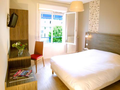 洛里昂渔民酒店的卧室配有床、椅子和窗户。