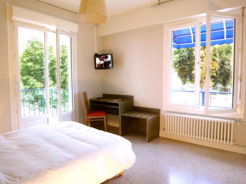 洛里昂渔民酒店的卧室配有一张床、一张书桌和窗户。