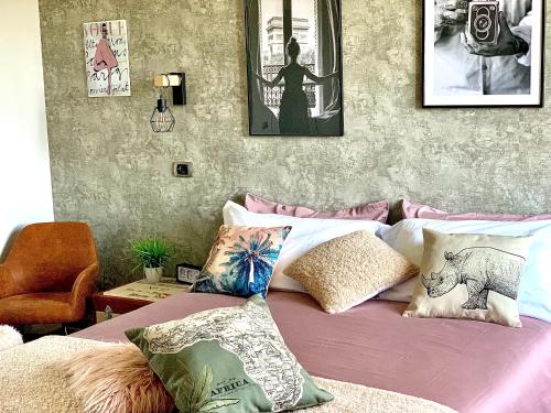 苏特里Goose House Luxury Holiday Home的一间卧室配有一张带枕头的床,墙上挂有图片