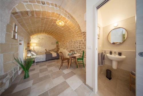 Minervino MurgeLa Ferula Magica - alloggio tipico的一间带水槽的浴室和一间带床的房间