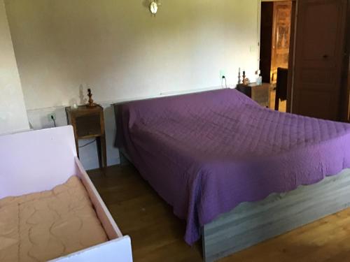BedousMaison Laclede的一间卧室配有一张带紫色床罩的床