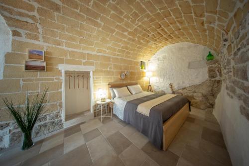 Minervino MurgeLa Ferula Magica - alloggio tipico的卧室配有砖墙内的床铺
