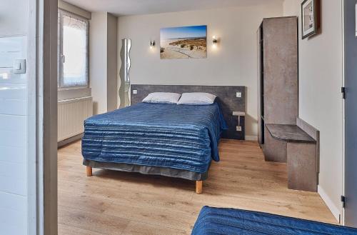 圣让-德蒙阿特兰提克酒店及餐厅的一间卧室配有一张带蓝色毯子的床