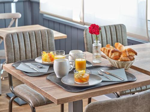 圣让-德蒙阿特兰提克酒店及餐厅的一张桌子,早餐包括咖啡和羊角面包