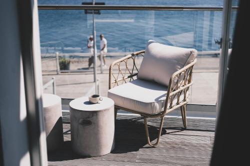 赫讷Skärgårdshotellet Hönö的俯瞰大海的阳台上的藤椅