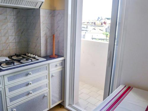 比亚里茨Apartment Océanic-1 by Interhome的一间带炉灶和窗户的小厨房