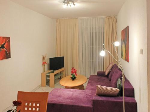 高尔维茨Apartment FIP-Ferienpark - Insel Poel-2 by Interhome的客厅配有紫色沙发和电视
