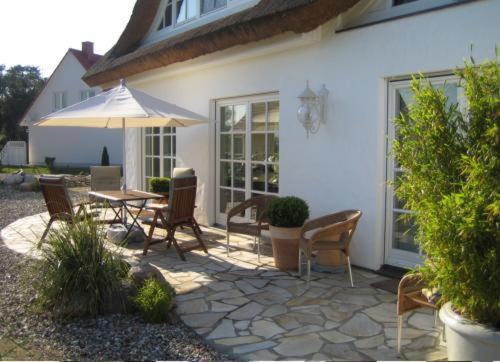 格洛韦Landhaus Glowe的庭院配有桌椅和遮阳伞。