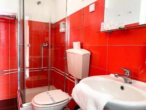 纳扎雷库巴塔酒店的红色的浴室设有卫生间和水槽