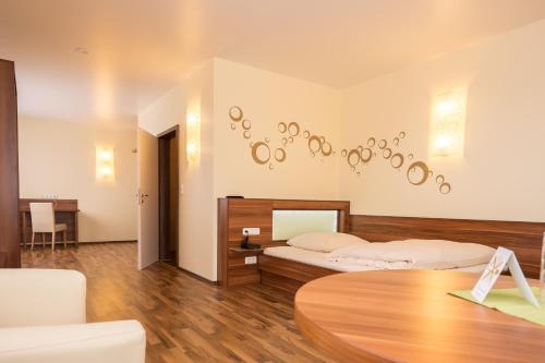 美因河畔霍海姆维奥拉酒店的一间卧室配有两张床和一张桌子
