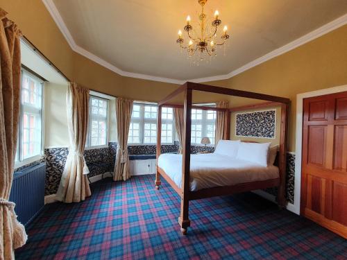塞尔柯克The Glen Guesthouse的一间卧室配有一张床、窗户和吊灯