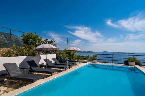 米利尼Apartments Villa Made 4U的毗邻度假酒店的带躺椅的游泳池