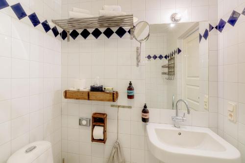 AbbekåsBongska Huset的白色瓷砖浴室设有水槽和卫生间