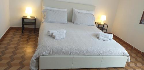 LocanaLa Casetta nel cuore del Parco的卧室配有带毛巾的大型白色床