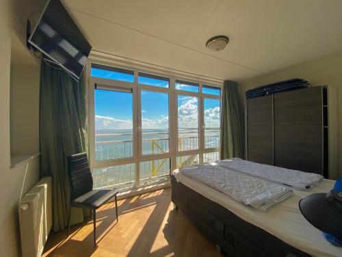 布雷斯肯斯Hello Zeeland - Appartement Port Scaldis 21-072的一间卧室设有一张床和一个大窗户