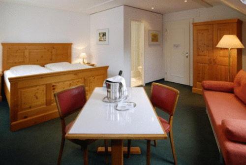 瓦伦施塔特丘坲斯坦酒店的配有桌椅和床的房间