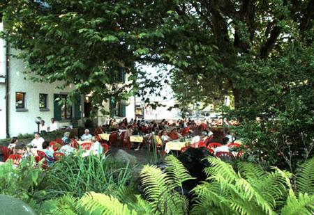 瓦伦施塔特丘坲斯坦酒店的坐在花园桌子上的一群人