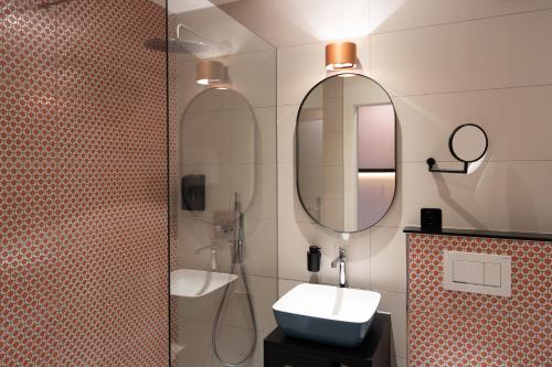施坦斯Boutique Hotel Stanserhof的一间带水槽和镜子的浴室