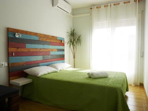 马尔格莱特德玛Apartamento Dayok Costa Barcelona的一间卧室配有一张绿色的床和木制床头板