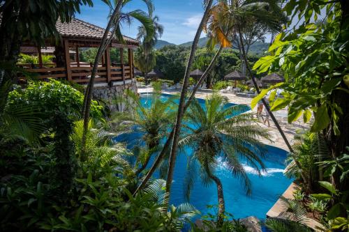 皮雷诺波利斯Pousada dos Pireneus的棕榈树蓝色泳池度假酒店