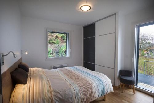 塞夫里耶Appartement Tournette - Vue Lac的一间卧室设有一张床、一个窗口和一把椅子
