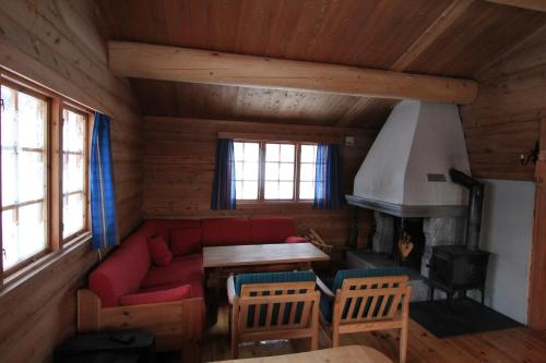 黑达尔卢萨特小木屋酒店的客厅设有红色的沙发和壁炉