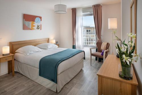 昆西苏斯纳特Domitys La Serpentine的酒店的客房 - 带一张床、椅子和窗户