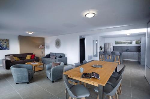 塞夫里耶Appartement Semnoz - Vue Lac的用餐室以及带桌椅的起居室。