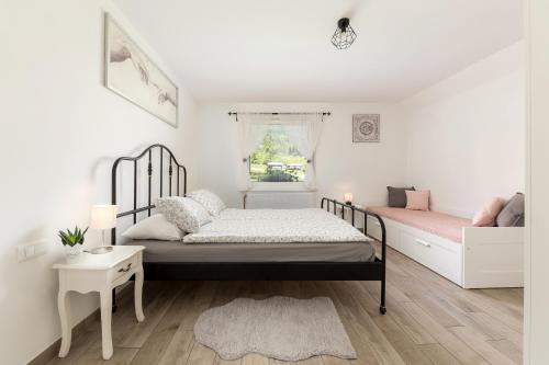 博希尼Pod Koblo Bohinj Apartments的一间卧室设有两张床和窗户。