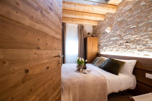 ConcoAntico Borgo Brunelli的一间卧室设有一张床和石墙