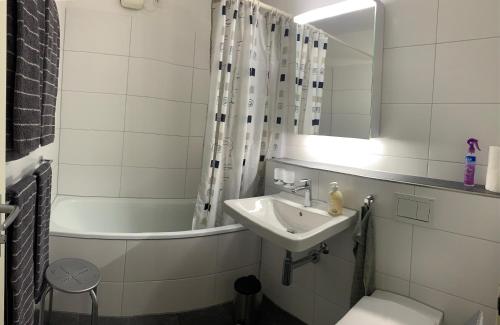 达沃斯Quellenhof C01的浴室配有盥洗盆、卫生间和浴缸。