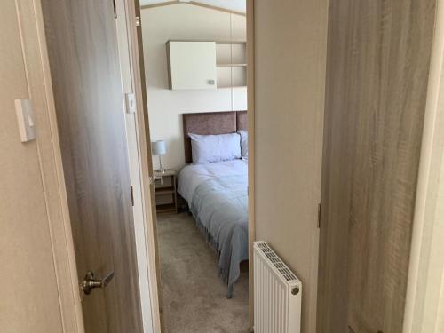 SwayForest Haven的一间小卧室,配有一张床和镜子