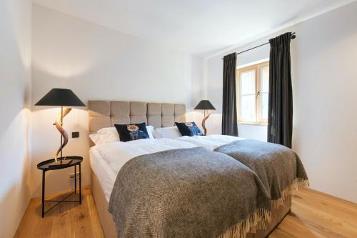 圣安东阿尔贝格Chalet Marmotta NEVE - Luxus Chalet的一间卧室设有一张大床和一个窗户。
