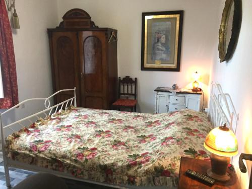 巴什卡沃达Vintage House for rent 60m from Sea的一间卧室配有一张床和一张带台灯的桌子