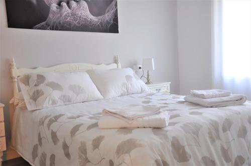 拉瓜迪亚SEVILLA I Y SEVILLA II的一张白色的床,上面有两条毛巾