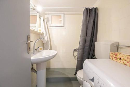 艾丽奇Nisos cottage house的白色的浴室设有水槽和卫生间。