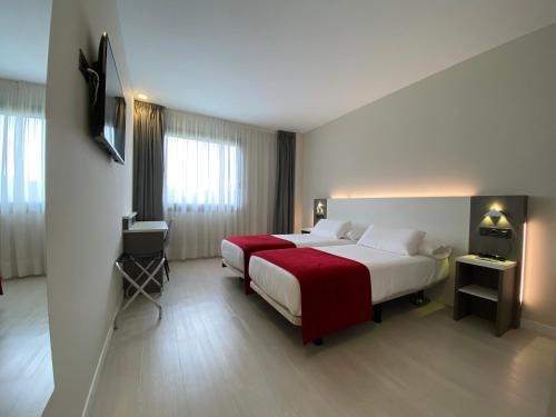 德里奥新毕尔巴鄂机场酒店的酒店客房设有两张床和电视。