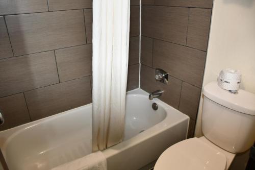 斯蒂尔沃特Stillwater Inn & Suites的一间带卫生间、浴缸和淋浴的浴室