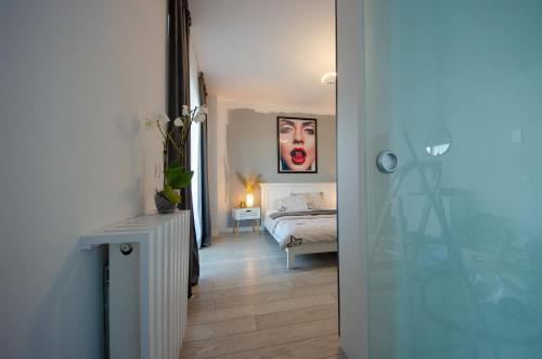 特尔古穆列什Bliss Apartment的卧室配有一张床,墙上挂有绘画作品