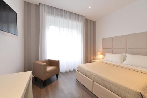 罗马弗拉米尼奥旅馆的一间卧室配有一张床、一把椅子和电视