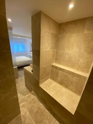 尼姆Feel@Home Nemausus « Le 21 »的一间石墙浴室和一张位于客房内的床