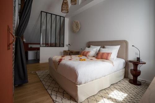 兰斯KRAFFT, centre ville, climatisé, baignoire double - La Clé des Sacres的一间卧室配有带白色床单和橙色枕头的床。