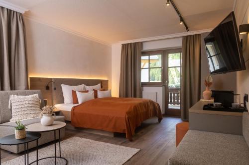 皮茨河谷圣莱昂哈德Verwöhn-Harmoniehotel Mandarfnerhof的酒店客房,配有床和沙发