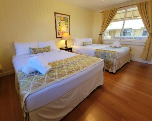 哈威Kohala Village INN的一间卧室设有两张床和窗户。