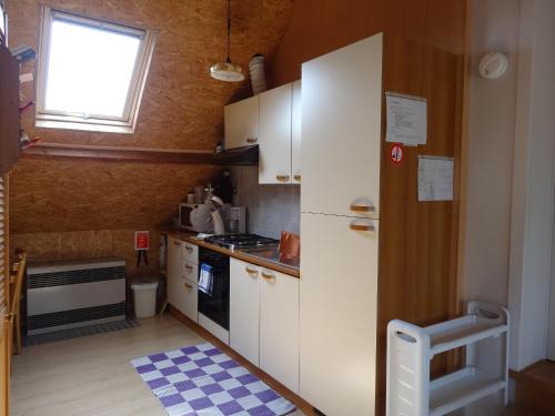 Merkem帕林特公寓的一间小厨房,配有白色的橱柜和窗户