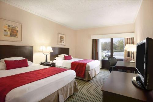 纽瓦克华美达纽华克/威尔明顿区酒店的酒店客房设有两张床和一台平面电视。